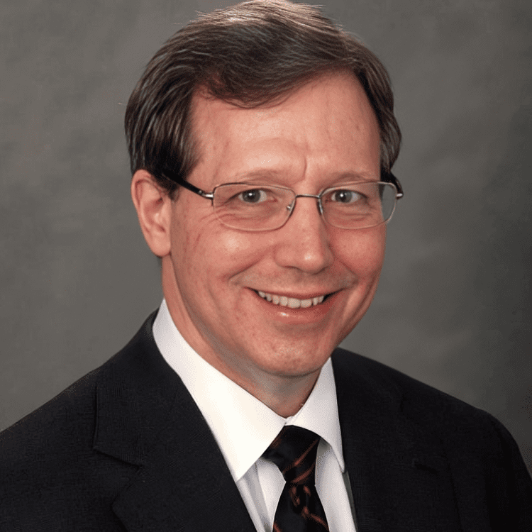 Smiling man in suit and tie.